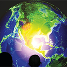 people looking at a lighted globe map